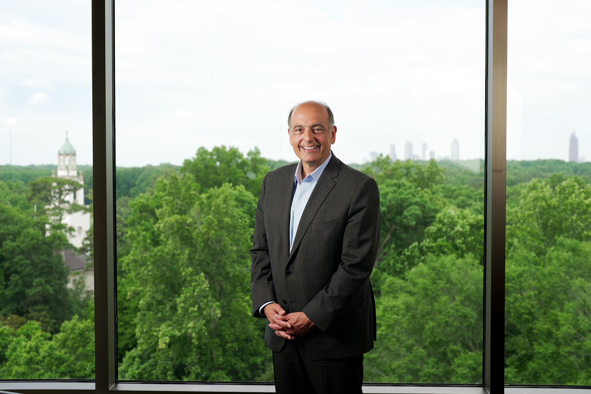 chris augostini posing in the rose library in front of window with skyline behind